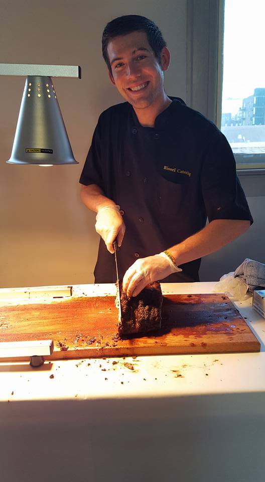 caterer carving meat on board at carving station